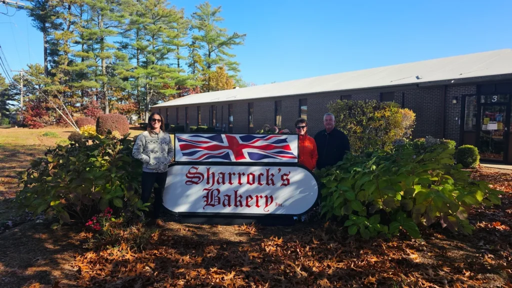 A group of people standing next to a sign.